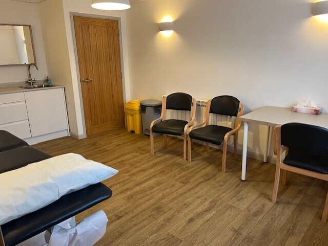 Treatment Room 1: CQC registered, equipped with couch. screen, sink, desk, chairs with natural light. 