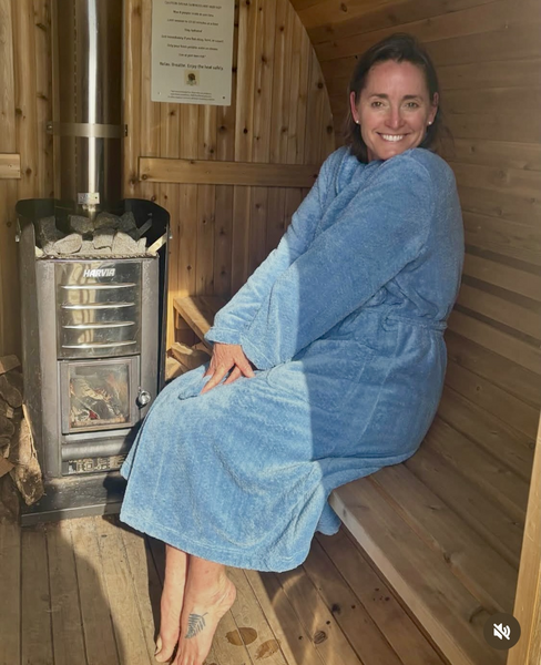 Robed guests relaxing inside a mobile sauna after ocean swimming in Narragansett